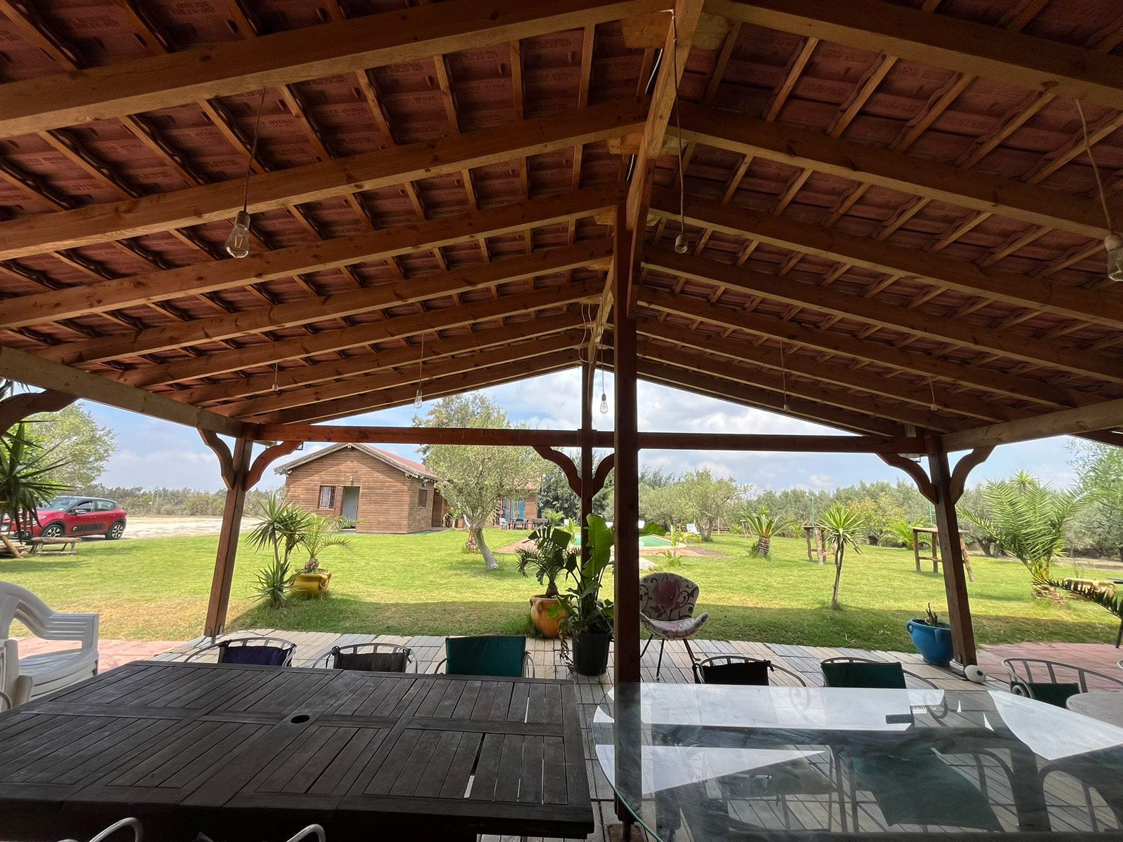 Vue sur le jardin depuis l’espace couvert sous la charpente en bois